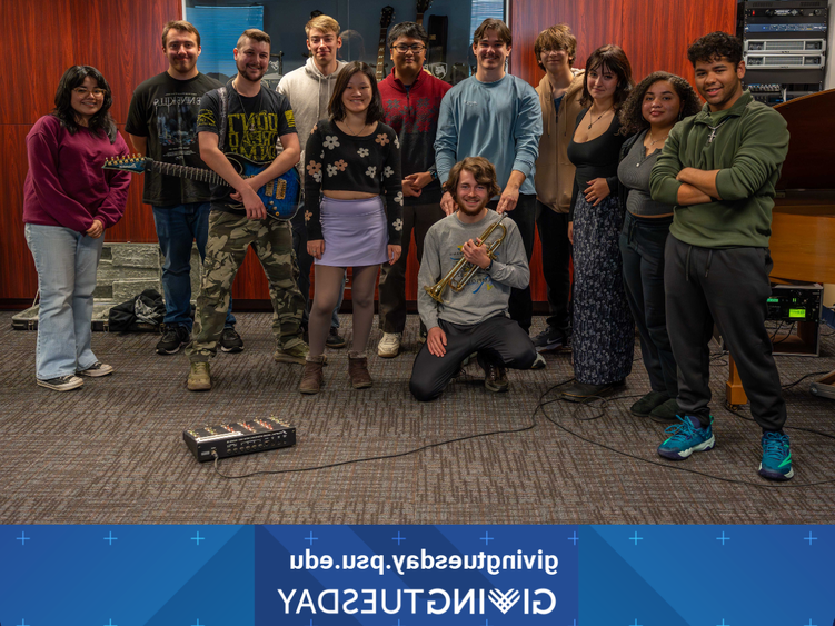 a group of students smile in a room full of instruments